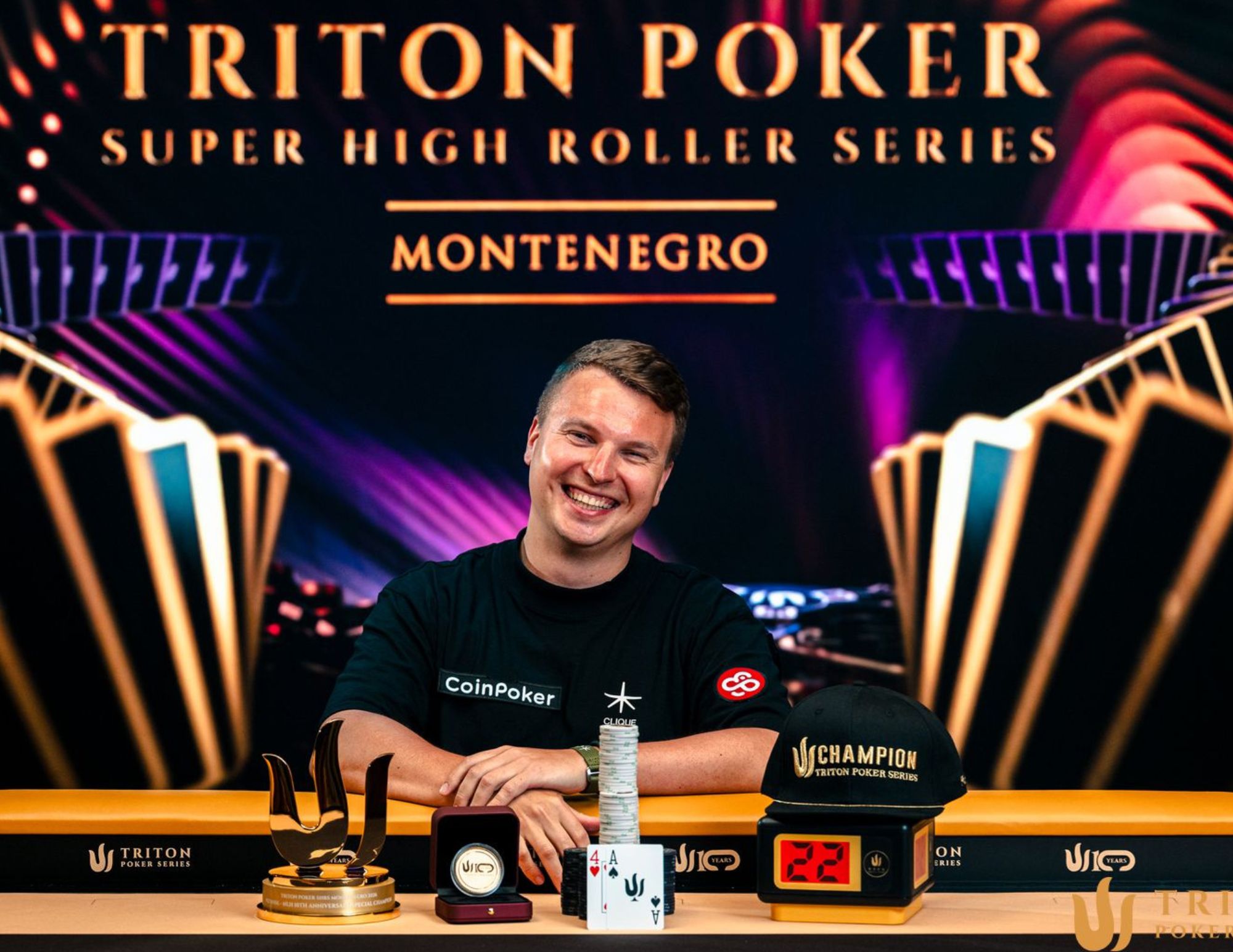 Aleks Ponakovs świętujący zwycięstwo przy stole pokerowym Triton Poker.