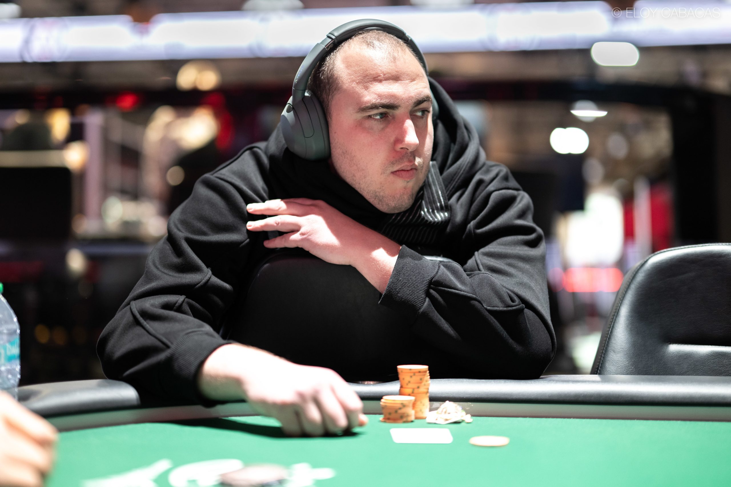 Gracz pokerowy siedzący przy stole finałowym turnieju, z dumą reprezentujący Palestynę.
