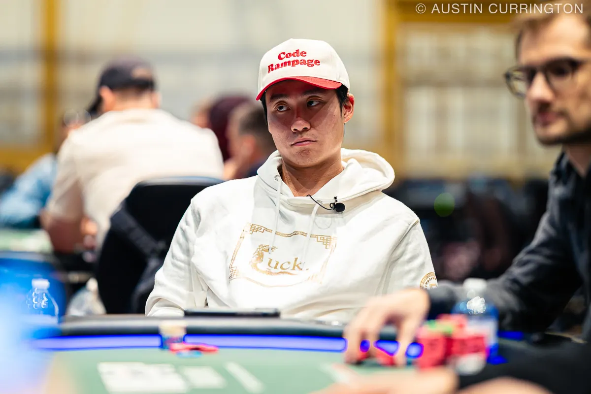 Pokerzysta grający w grze cashowej high stakes przy stole pokerowym.