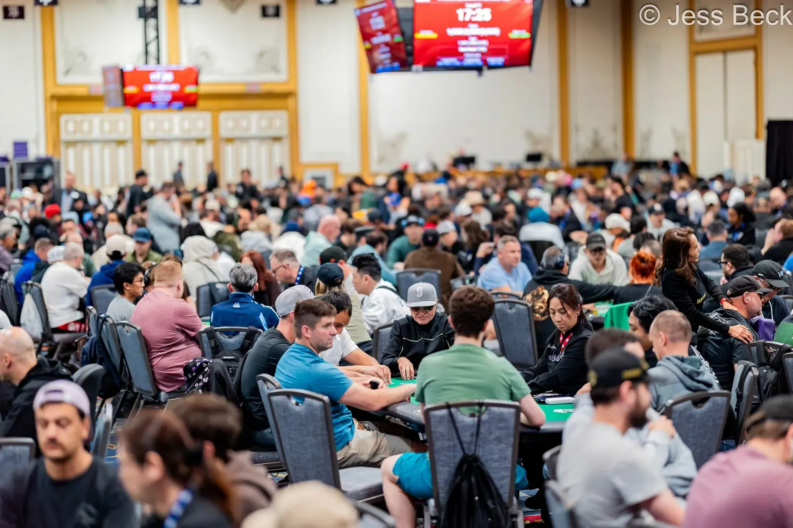 Gracze przy stole pokerowym podczas turnieju World Series of Poker z żetonami i kartami