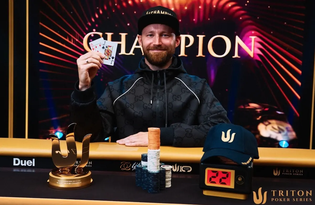 Aliaksei Boika świętuje zwycięstwo w turnieju Triton Poker Series w Jeju z trofeum i czapką mistrza